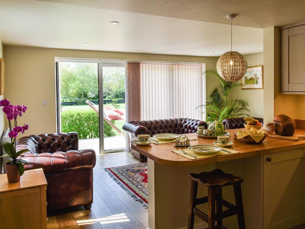 a kitchen with a table and a living room at Swallowtail Lodge in Brundall