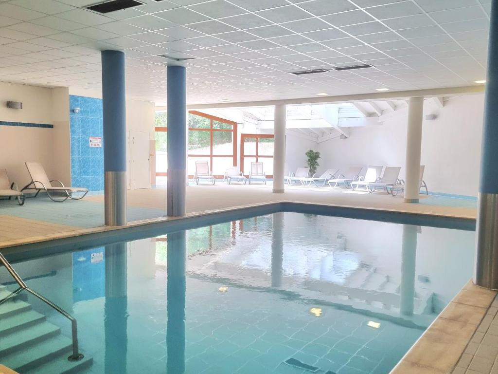 une piscine avec de l'eau bleue dans un immeuble dans l'établissement Studio Le Panoramic les Balcons d'Aix, à La Féclaz