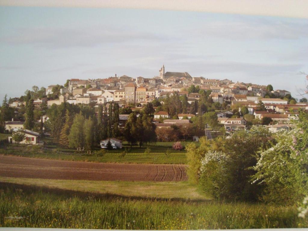 une ville au sommet d'une colline avec des maisons dans l'établissement Gîte des Augustins, à Monflanquin