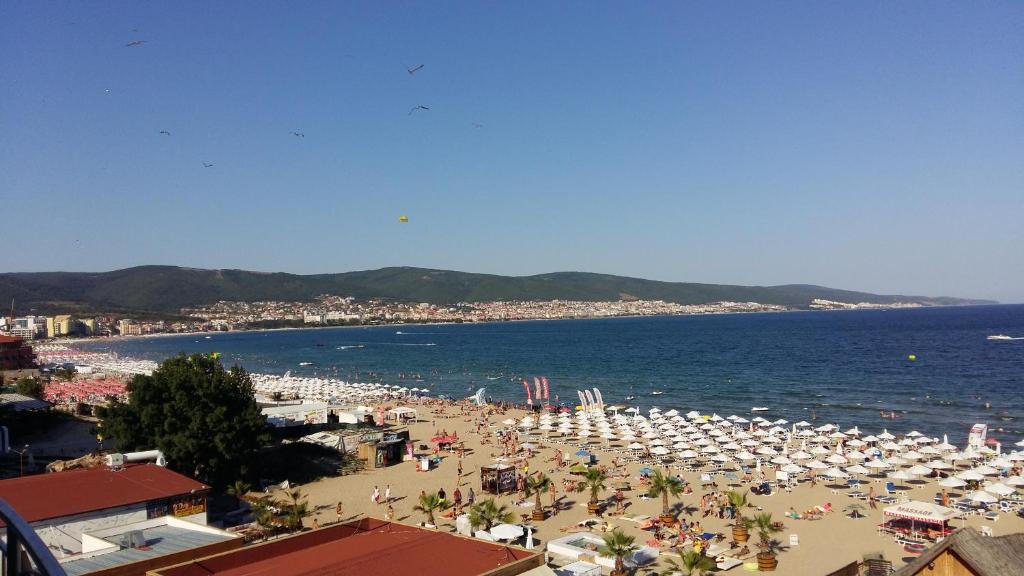 ein Strand mit vielen Sonnenschirmen und Menschen darauf in der Unterkunft Kaya Apartments in Sonnenstrand