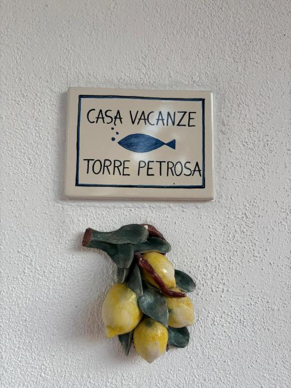 a sign on a wall with a pile of pears at Case Vacanze Torre Petrosa in Villammare