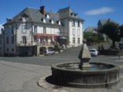 a statue in front of a building with a house at Auberge De Raulhac in Raulhac