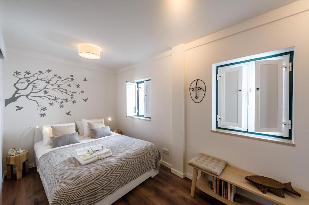 1 dormitorio con 1 cama y una pegatina de árbol en la pared en Studio Galé Terceiro, en Lisboa