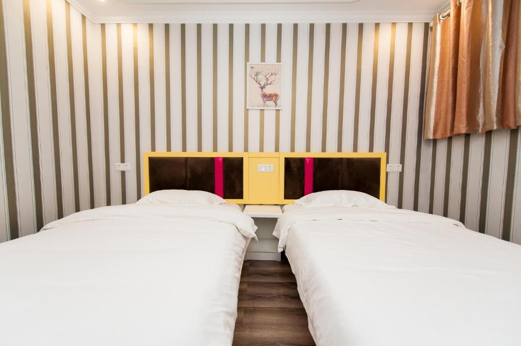 A bed or beds in a room at Weiyi Boutique Hotel