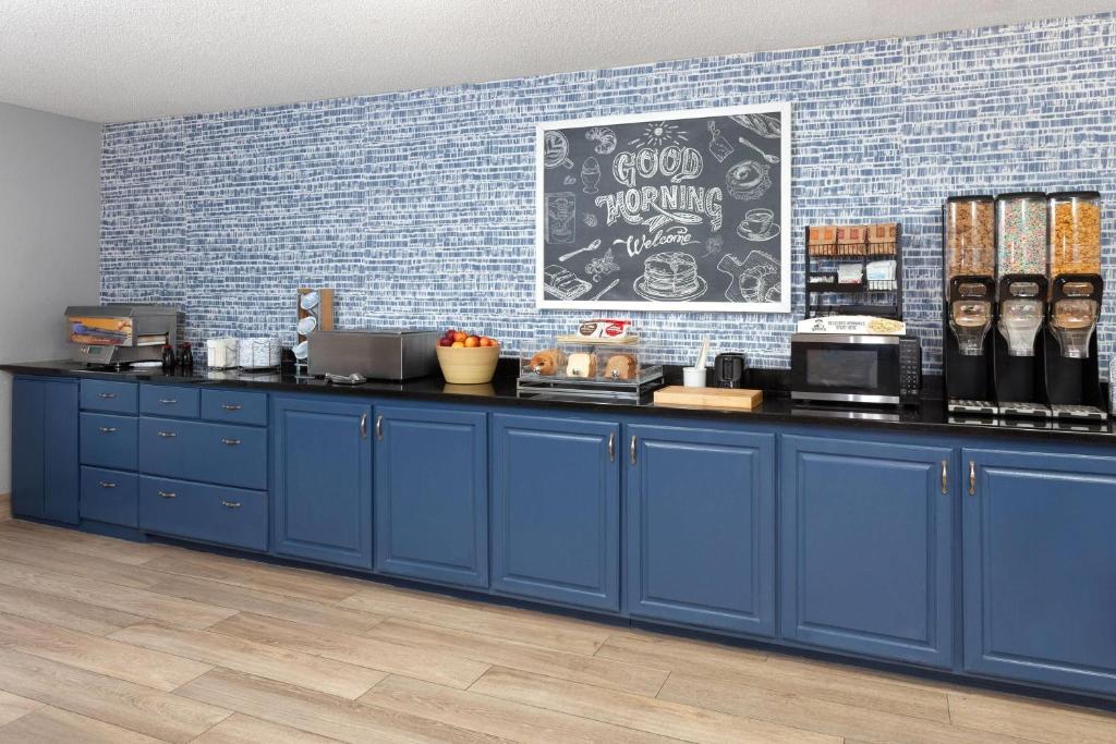 a blue counter in a restaurant with a blue wall at AmericInn by Wyndham Reedsburg in Reedsburg