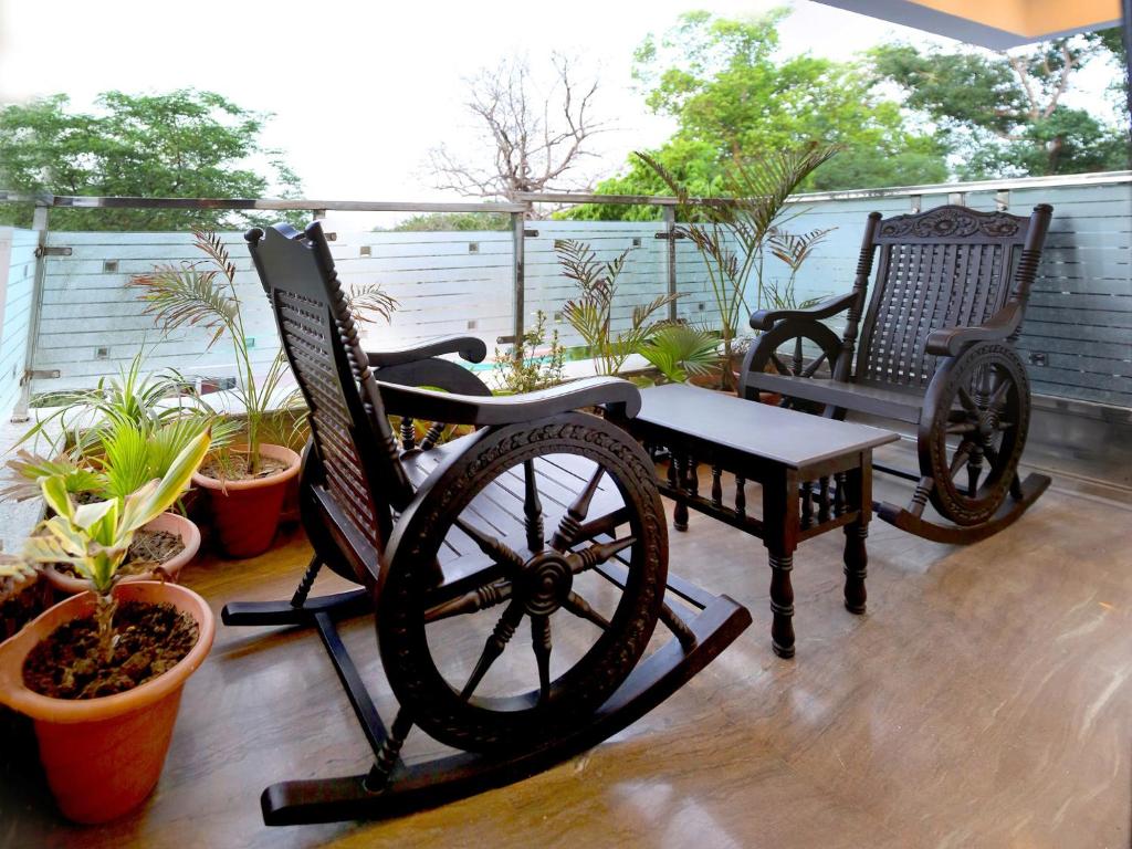 zwei Schaukelstühle und eine Bank auf einer Veranda in der Unterkunft Pearl of Taj Home Stay in Agra