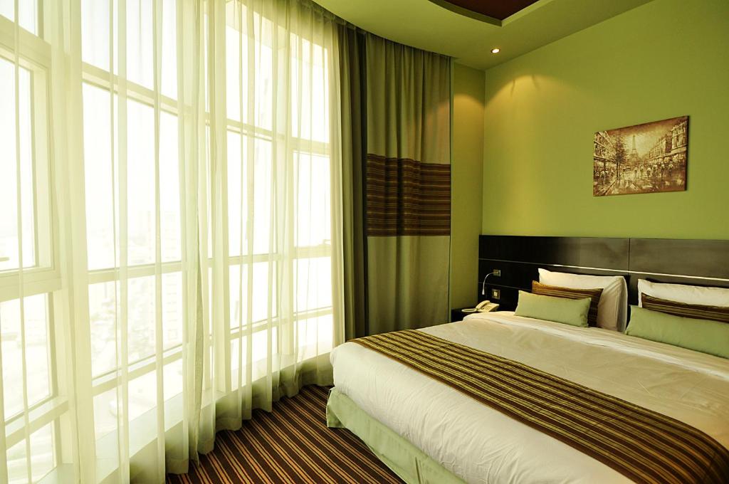 Postel nebo postele na pokoji v ubytování Aldar Hotel