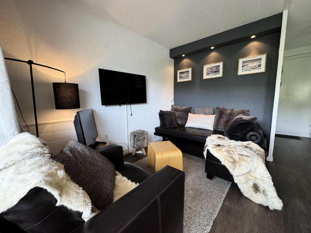un salon avec un canapé et une télévision dans l'établissement Résidence Necou - Duplex de 3 pièces pour 4 personnes avec grand balcon MAE-4081, aux Menuires