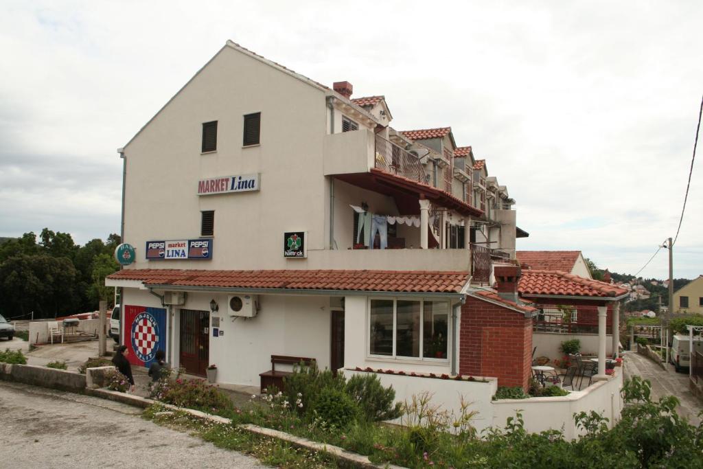 un edificio blanco con techo rojo en Apartman Miro, en Cavtat