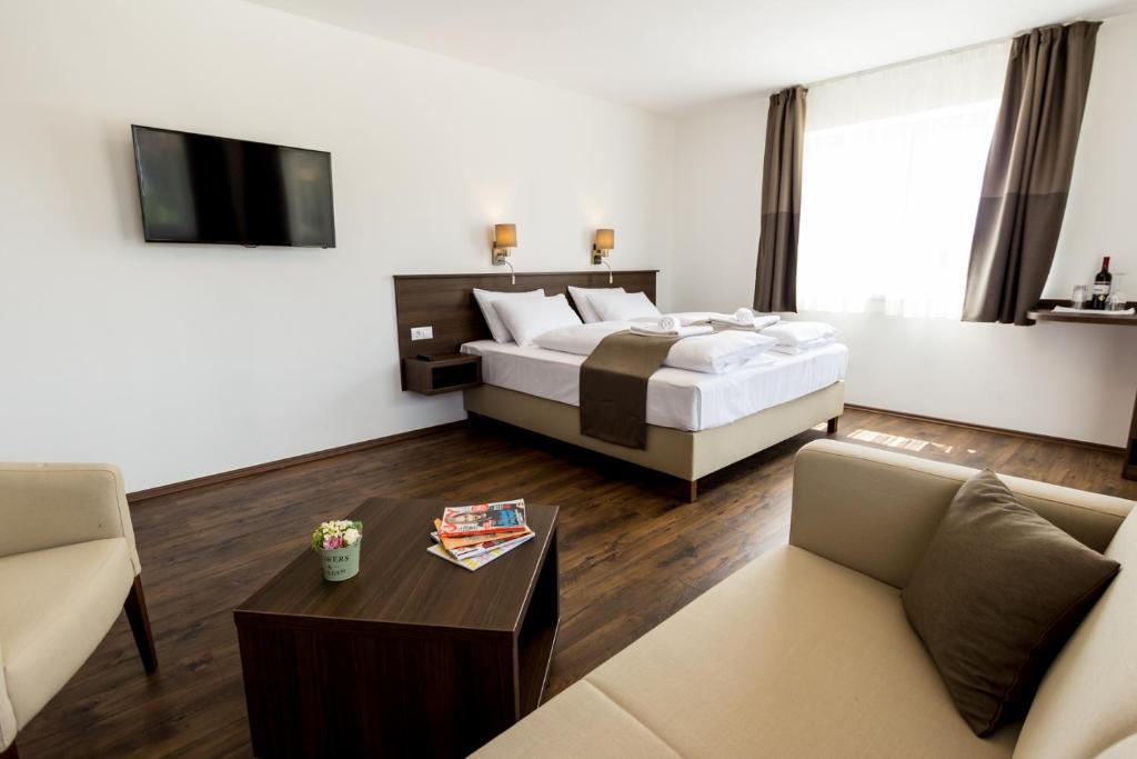 Pokój hotelowy z łóżkiem, kanapą i stołem w obiekcie Friskó Panzió w Zalakaros