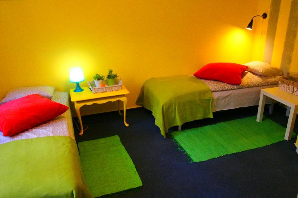 Habitación con 2 camas y almohadas verdes y rojas. en Kamienica Górna 7 en Olsztyn