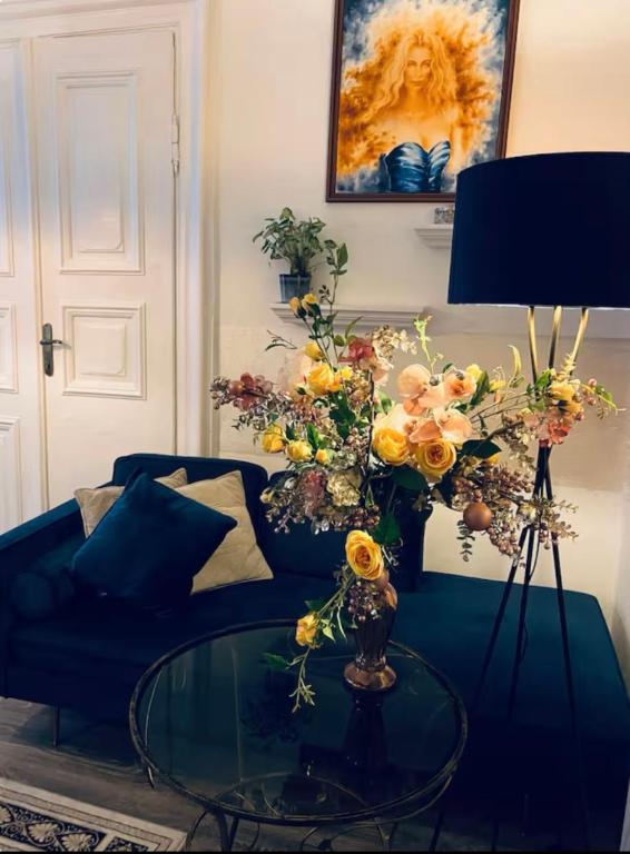 a living room with a couch and a glass table with flowers at CpB3 in Bratislava