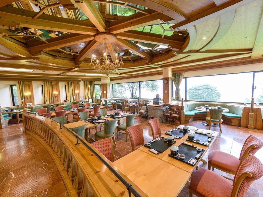 une grande salle à manger avec tables et chaises dans l'établissement South Aso and Relaxing Spa Resort Hotel Greenpia Minamiaso, à Minami Aso