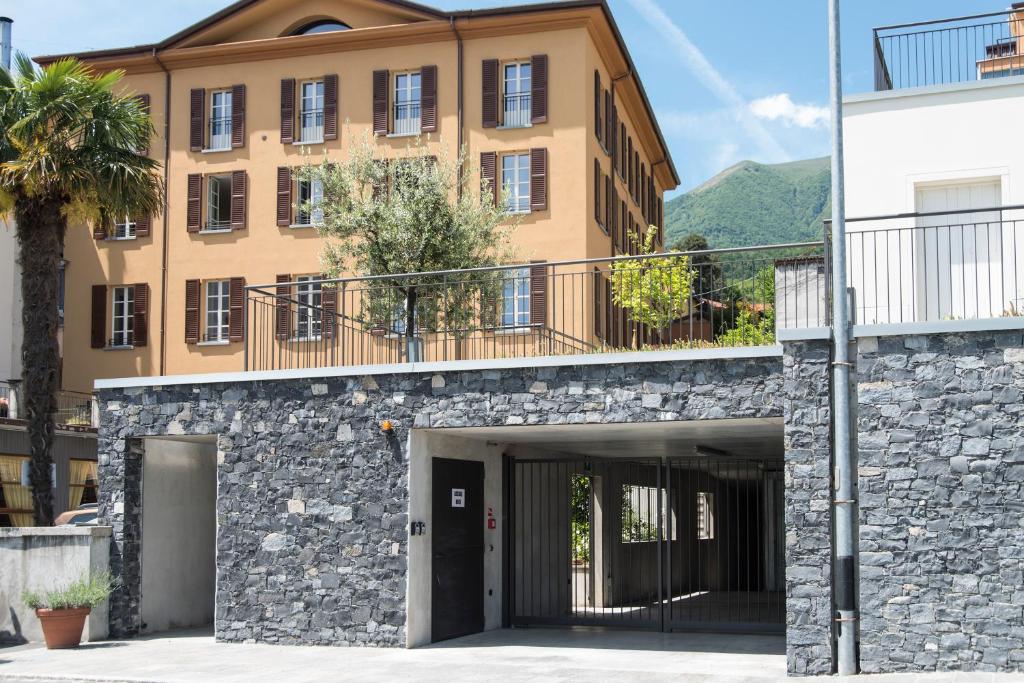 un gran edificio con una pasarela delante de él en Maioliche Apartments Griante, en Cadenabbia