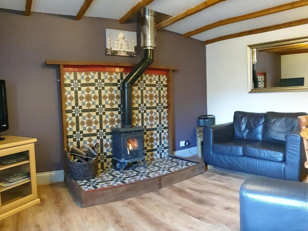 ein Wohnzimmer mit Kamin und Couch in der Unterkunft Fitling Cottage in Garton