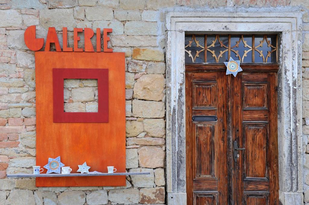drewniane drzwi i znak na ceglanym budynku w obiekcie Galerie Kuks w mieście Kuks