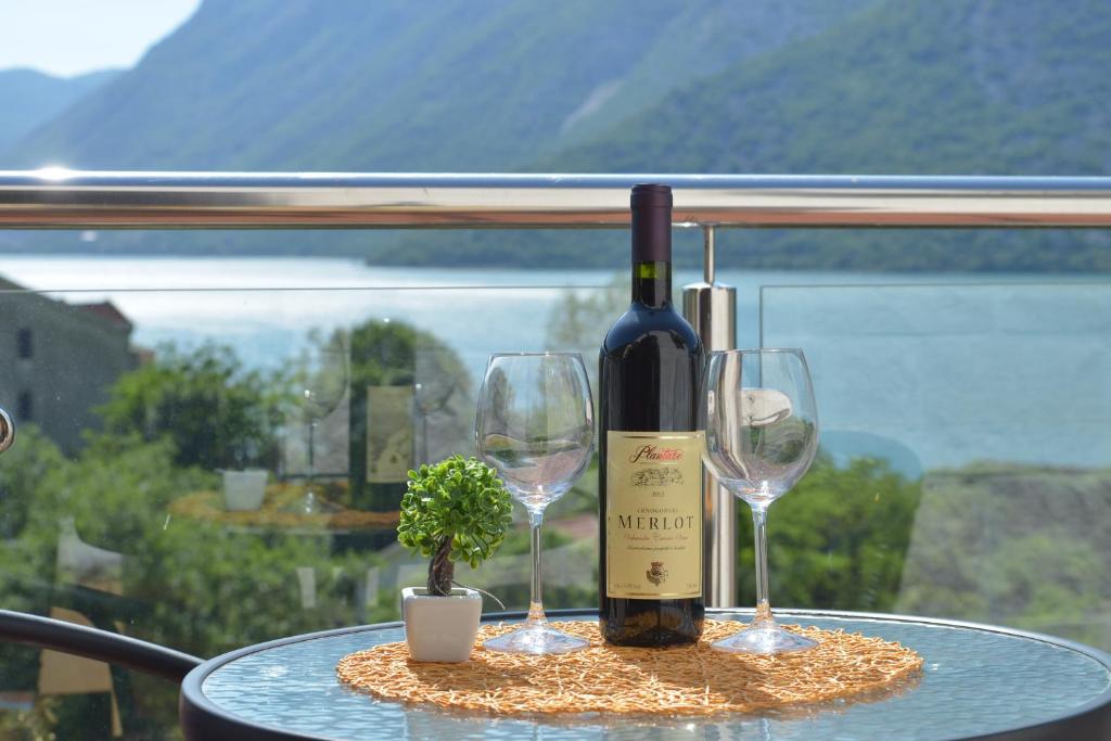 una bottiglia di vino e due bicchieri su un tavolo di Apartments Villa Illyrik a Risan
