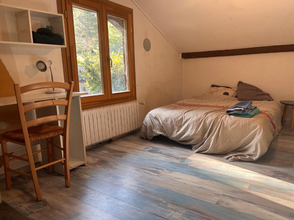 une chambre avec un lit, une chaise et une fenêtre dans l'établissement Chambre Cosy , sub et wc privatif , chez l'habitant avec piscine, à La Celle-sous-Gouzon