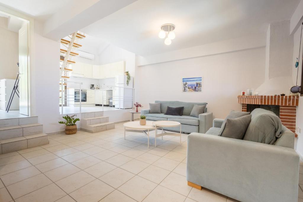 a living room with two couches and a fireplace at Veranda Seaview Residence in Pefkochori