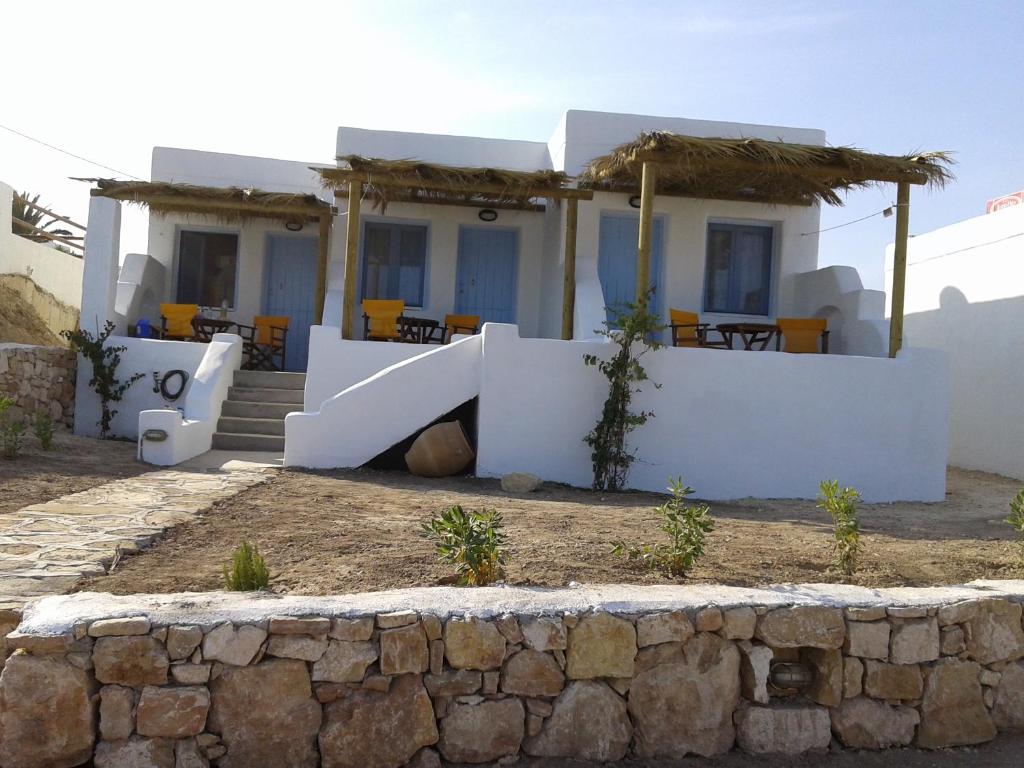 a house with a stone wall in front of it at Ammos Studio in Koufonisia