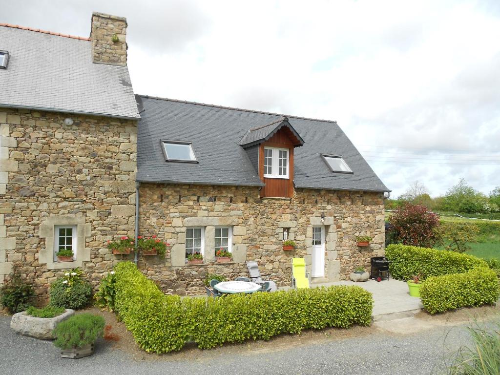 a stone house with bushes in front of it at Gîte de Kervoas in Lézardrieux