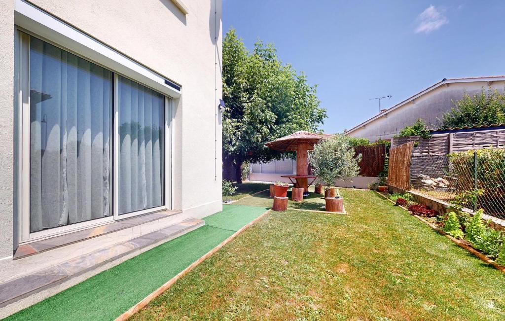 a house with a green lawn next to a building at Belle Maison Avec Spa in Tournon-dʼAgenais