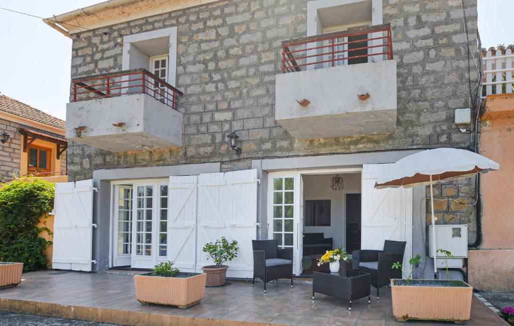 un edificio con patio con sillas y sombrilla en Appartement Calanches Piana, en Piana