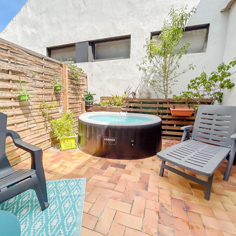 un patio avec un jacuzzi avec deux chaises et une table dans l'établissement Studio Avec SPA Proche Centre, à Carcassonne