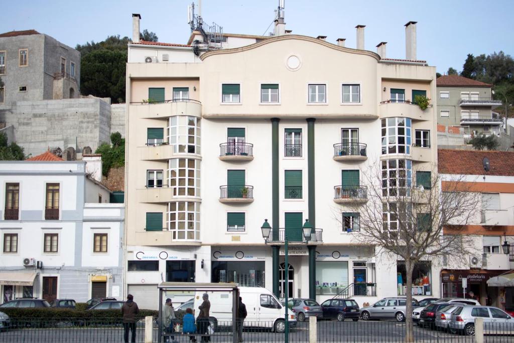 un bâtiment blanc avec des voitures garées devant dans l'établissement AL embaixador, à Alenquer