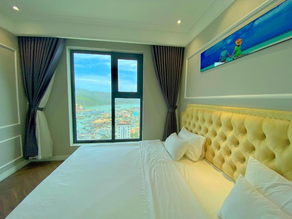 a bedroom with a bed with a large window at Amanda Apartment Quy Nhon in Quy Nhon