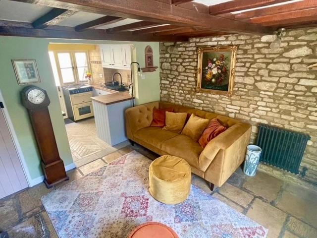 a living room with a couch in a kitchen at Cozy Cotswold Burford Cottage in Burford