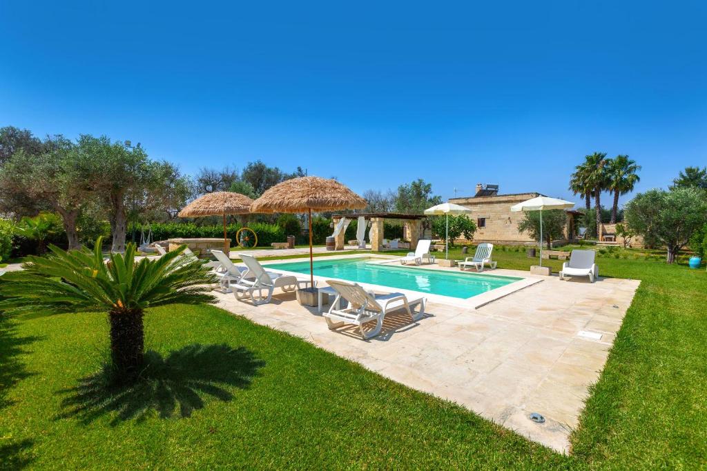 a swimming pool with chairs and umbrellas in a yard at Villa Saracino by Perle di Puglia in Supersano