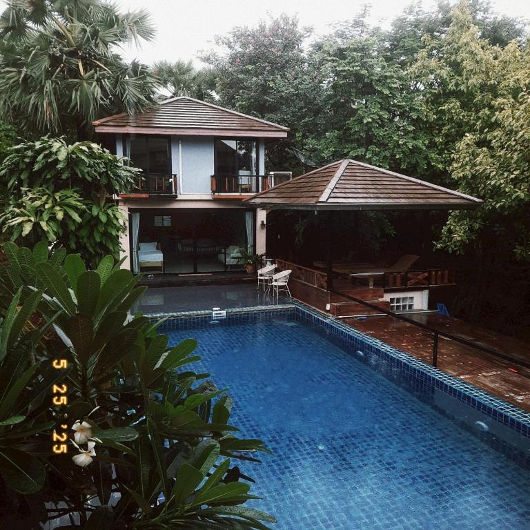 a villa with a swimming pool in front of a house at The Leaf Pool Villa Resort in Muak Lek District