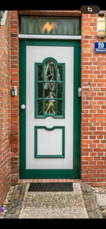 a green and white door with a window on it at Ferienwohnung am Sandwater in Ihlow