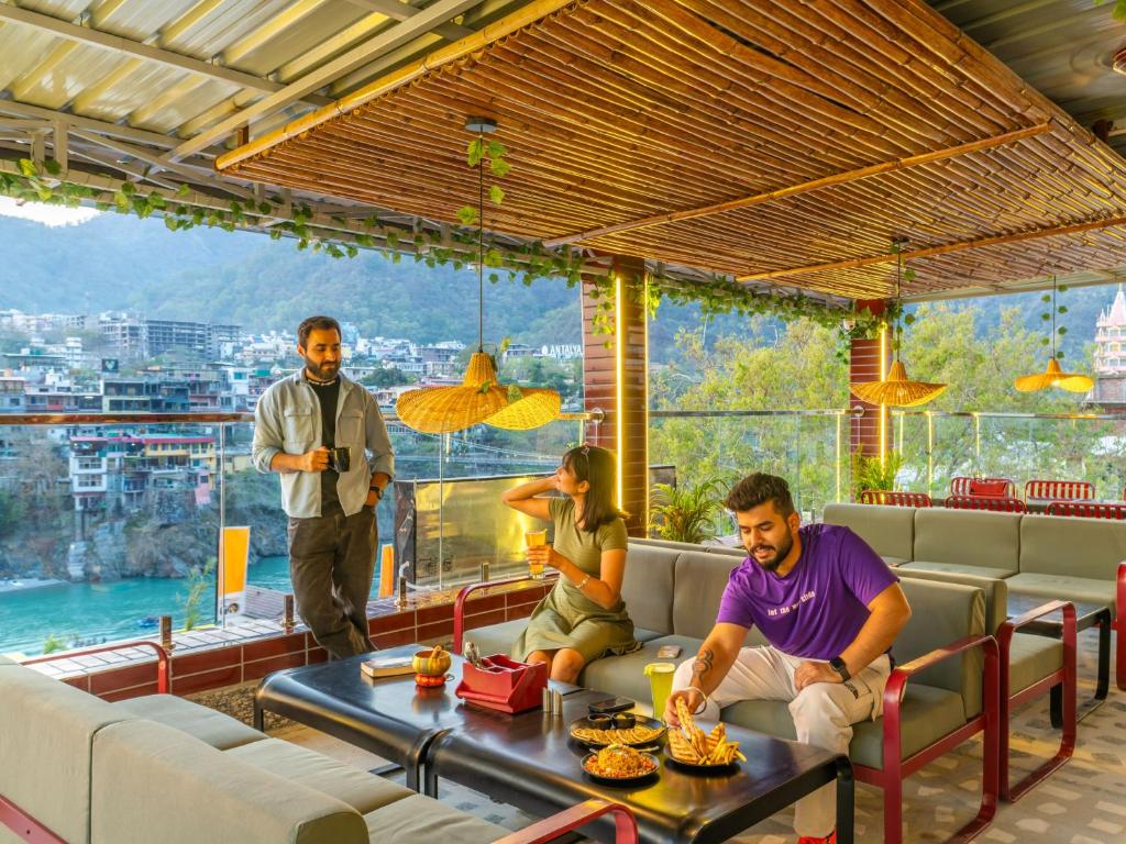 um grupo de pessoas sentadas ao redor de uma mesa em um restaurante em The Hosteller Rishikesh, Ganges em Rishikesh