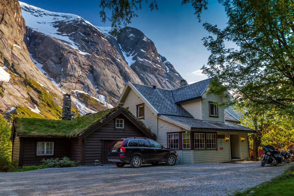 a car parked in front of a house with a mountain at Lunde Turiststasjon in Skei 
