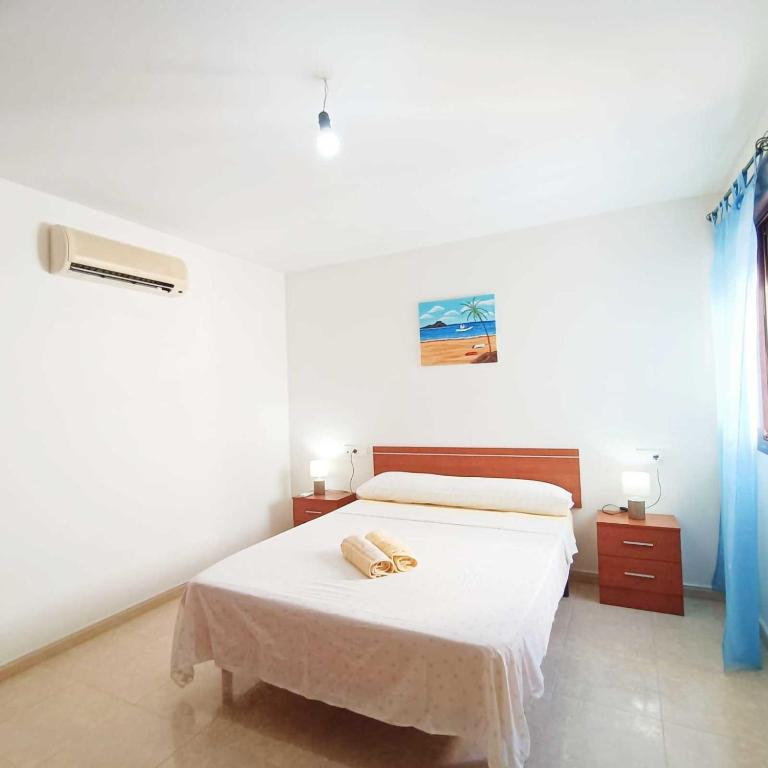 biała sypialnia z łóżkiem z 2 ręcznikami w obiekcie Miralmar 2 - Apartamento a 50 metros de la playa w mieście Carboneras