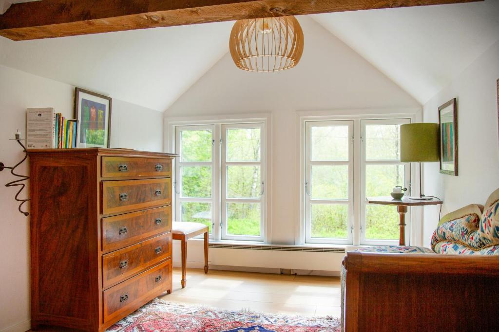 a bedroom with a dresser and two windows at The Hallandsåsen Lighthouse, A Natural Retreat in Munka-Ljungby
