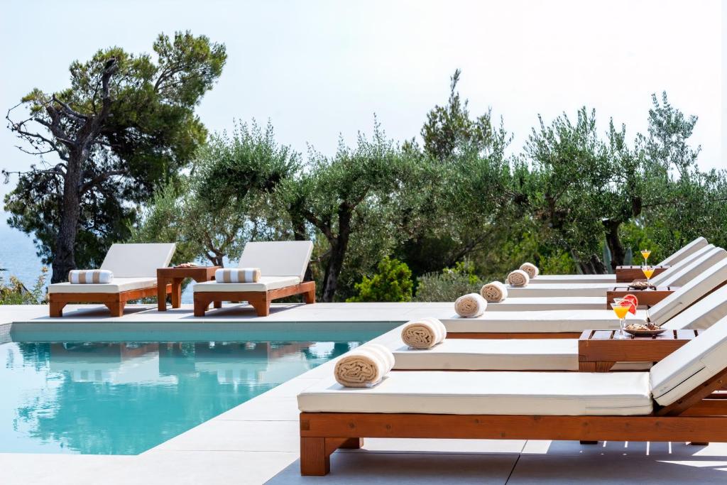 a pool with chaise lounges and chairs next to the water at Marevita in Podstrana