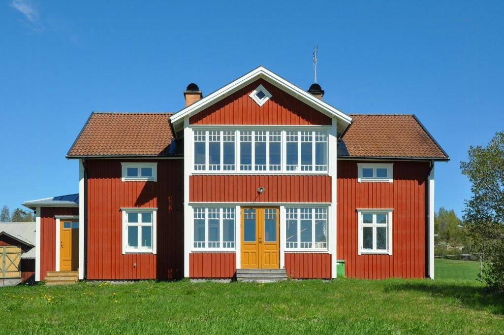 a large red house with a red roof at Turn-Of-The-Century House Near Lake Vikarn in Matfors