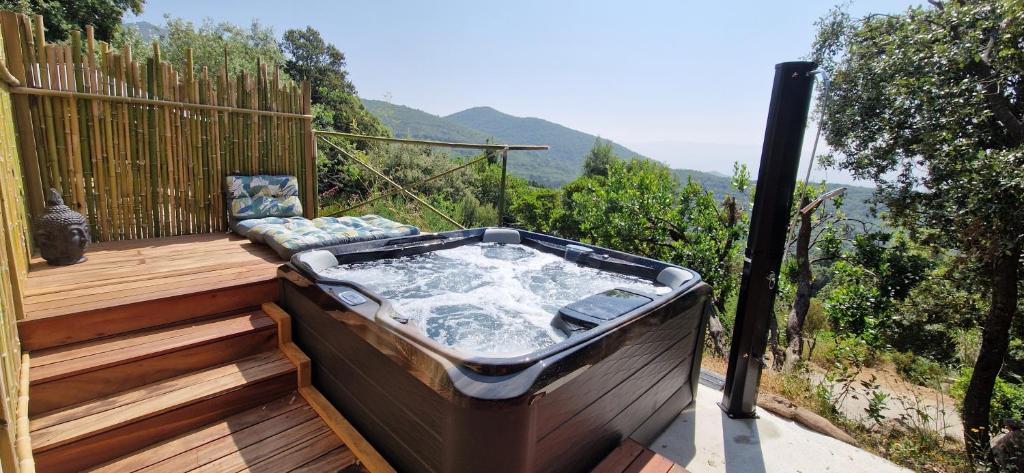 un bain à remous installé au-dessus d'une terrasse en bois dans l'établissement Sottu E Stelle, à Albitreccia
