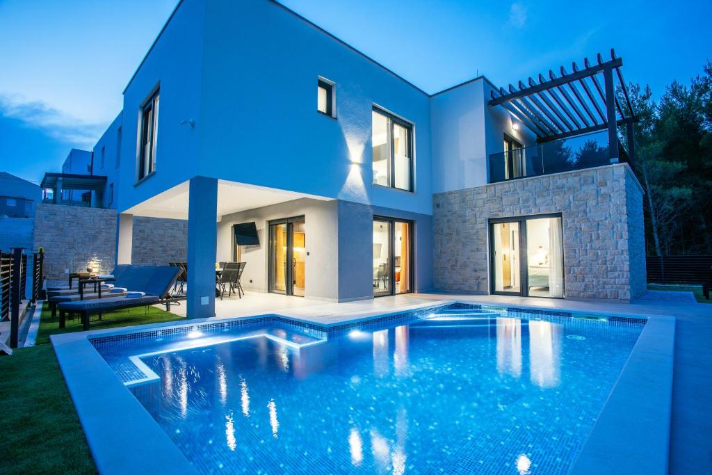 a large swimming pool in front of a house at Villa Nina - Tugare, Omis in Tugare