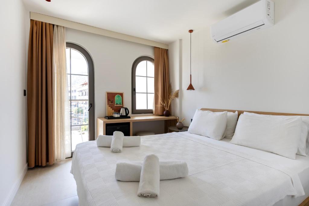 a white bedroom with a large white bed with two pillows at Casa Dalida Boutique Hotel in Datca