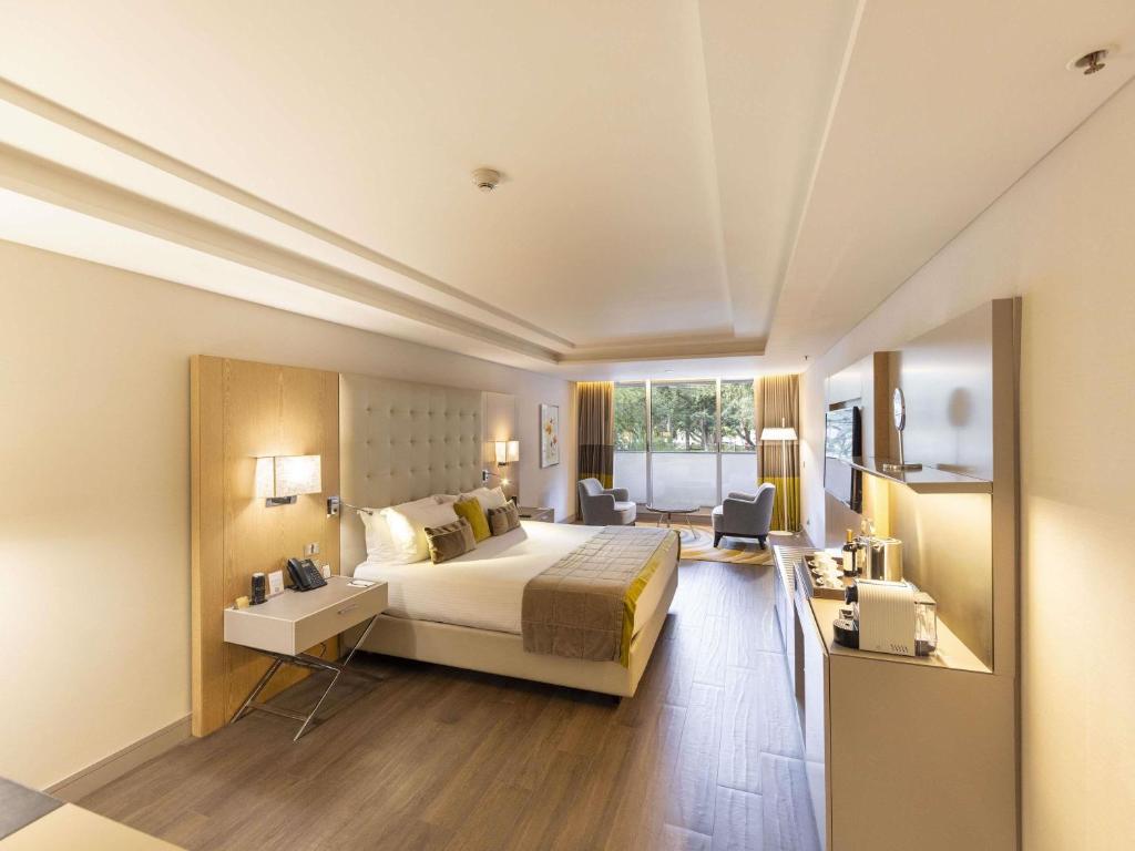 una camera d'albergo con un letto e una grande finestra di Palladio Hotel Buenos Aires - MGallery Collection a Buenos Aires