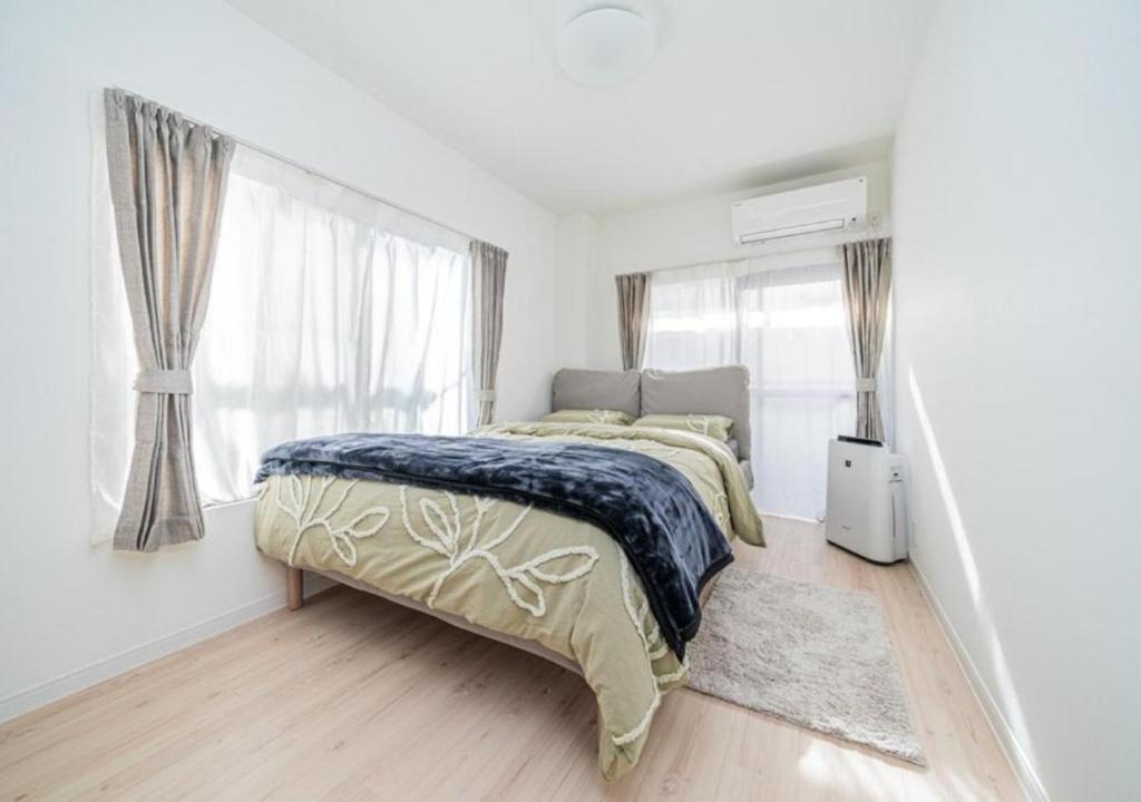 Un dormitorio blanco con una cama y una ventana. en Kasai Light Luxury Hotel 201, en Tokio