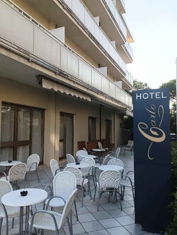 a row of tables and chairs in front of a hotel at Hotel CARLO in Riccione