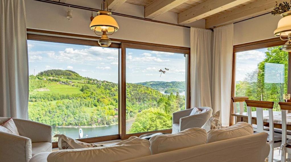 a living room with a large window with a view at Dom Tabaszowa 182 - Jezioro Rożnowskie in Tabaszowa