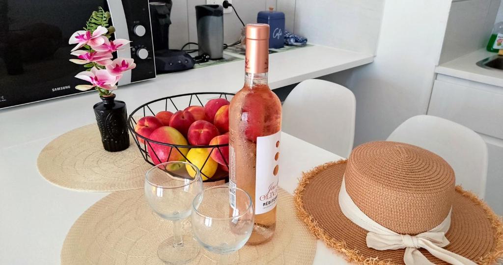 une bouteille de vin et une corbeille de fruits sur une table dans l'établissement Provence apartments, à Aix-en-Provence