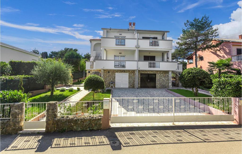 a white house with a gate in front of it at Nice Apartment In Silo With Wifi in Šilo