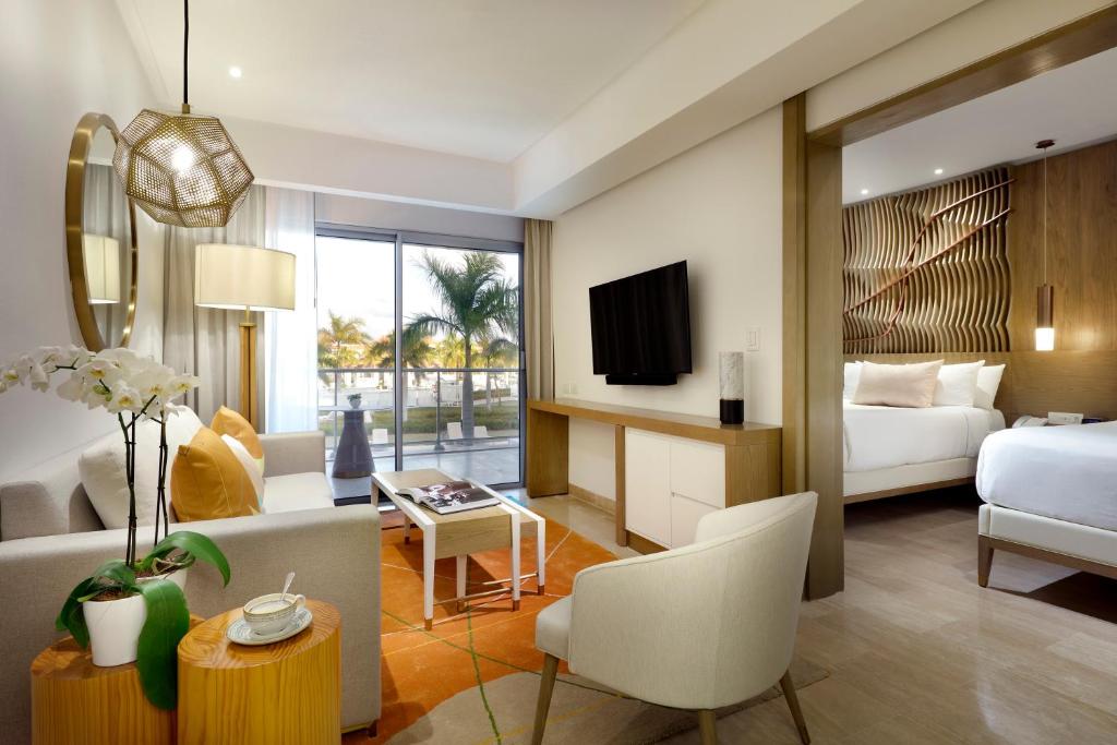 Una habitación de hotel con una cama y una sala de estar. en Paradisus Grand Cana, All Suites - Punta Cana -All Inclusive, en Punta Cana